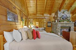 un grande letto in una stanza con camino di Do Not Disturb - Pigeon Forge Smoky Mountain Studio Cabin, Hot Tub, Fireplace a Pigeon Forge