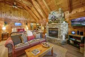 ein Wohnzimmer mit einem Sofa und einem Kamin in der Unterkunft Do Not Disturb - Pigeon Forge Smoky Mountain Studio Cabin, Hot Tub, Fireplace in Pigeon Forge