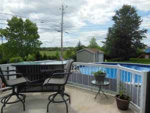 d'un balcon avec une table, des chaises et une piscine. dans l'établissement Gite Du Lac St-Prime, à Saint-Prime