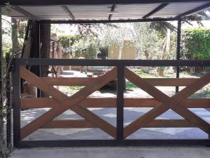 a wooden gate to a gate to a garden at Pequeña casa en chacras de coria in Chacras de Coria +26 photos