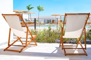 - deux chaises longues sur une terrasse avec piscine dans l'établissement Shambhala Fuerteventura, à Parque Holandes