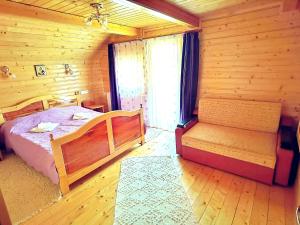 a bedroom with a bed and a bench in a cabin at Cabanele FloriCrin - Cabana 2 in Mărişel