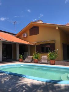 una piscina davanti a una casa di Linda casa com piscina em Bombinhas, espaço inteiro a Bombinhas