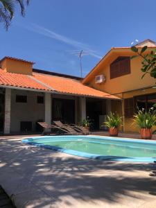 una piscina davanti a una casa di Linda casa com piscina em Bombinhas, espaço inteiro a Bombinhas