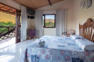 a bedroom with a bed with a blue comforter at Pousada Aconchego in Vale do Capao