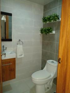 a bathroom with a toilet and a sink at Cozy apartment in exclusive area Bella Vista in Santo Domingo