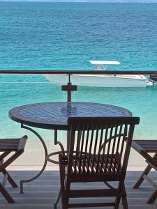 a table with a bench and a boat in the water at TIKI street side Studio with shared water front terrace at Grand Case in Grand Case