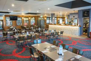 a restaurant with tables and chairs and a bar at Peppermill Inn Motel in Shepparton