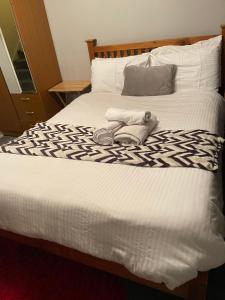 a bed with a pair of shoes on top of it at CyCy Apartment in Aberdeen