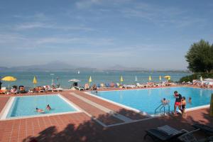 a large swimming pool with people in the water at Camping Wien in Peschiera del Garda