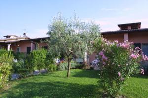 a yard with trees and flowers in front of a house at Camping Wien in Peschiera del Garda