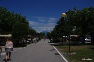 a woman walking down a street in a town at Camping Wien in Peschiera del Garda