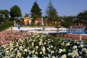 a garden with flowers in front of a building at Camping Wien in Peschiera del Garda