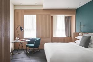 a hotel room with a bed and a chair and a desk at Kimpton Da An Taipei- an IHG Hotel in Taipei +37 photos