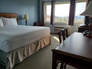 a hotel room with a bed and a desk with a desk at Carolyn Beach Inn in Thessalon