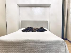 En eller flere senge i et værelse på FlatsinRoi Apartments