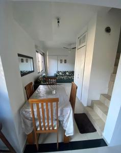 a dining room with a table and chairs and stairs at Novidade - Apto a 500 metros da praia da Enseada in Guarujá