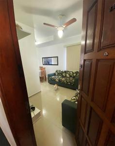 a living room with a couch and a dog in a room at Novidade - Apto a 500 metros da praia da Enseada in Guarujá