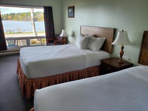 Thessalon的住宿－卡羅琳海灘汽車旅館，酒店客房设有两张床和窗户。
