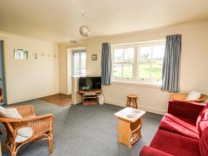 a living room with a red couch and a tv at Mullach in Lunga