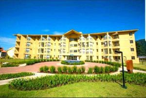 ein großes gelbes Apartmenthaus mit einem Innenhof in der Unterkunft Maravilhoso apartamento tipo loft na Reserva do Sahy em Mangaratiba RJ in Mangaratiba