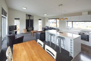 een keuken en een woonkamer met een tafel en stoelen bij Big Rock in Lake Tekapo