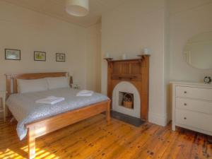a bedroom with a bed with a fireplace in it at Youngs Cottage in Port Fairy