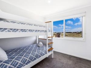 a bedroom with bunk beds and a window at Saltys in Port Fairy