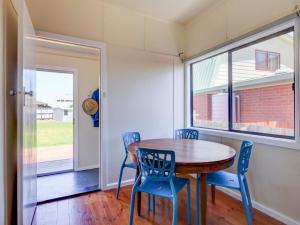 a dining room with a table and chairs and a window at Wings and Waves in Port Fairy