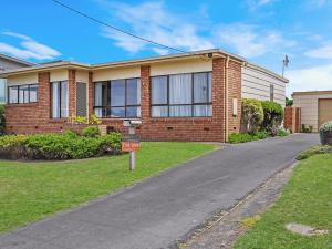 a brick house with a sign in front of it at Swimmers Rest 1 Bedroom in Port Fairy