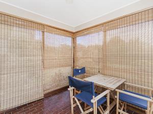 a room with a wooden table and two blue chairs at Swimmers Rest 1 Bedroom in Port Fairy