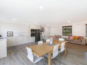 a kitchen and living room with a wooden table and chairs at Lyons in Port Fairy
