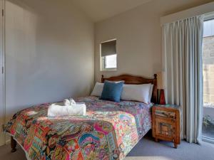 a bedroom with a bed with a teddy bear on it at Malahide in Port Fairy