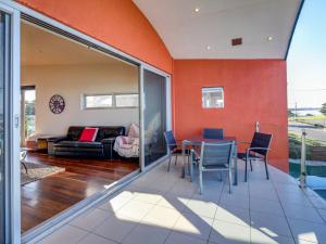 a living room with orange walls and a table and chairs at Malahide in Port Fairy