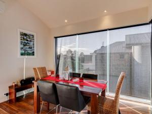 a dining room with a table and chairs and a large window at Malahide in Port Fairy