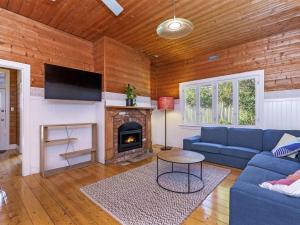 a living room with a blue couch and a fireplace at Avery Cottage in Port Fairy