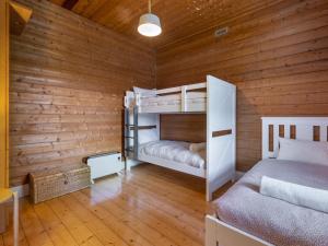 a bedroom with two bunk beds in a wooden wall at Avery Cottage in Port Fairy