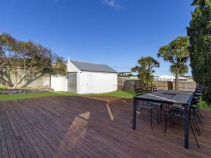 a patio with a table and chairs on a deck at Avery Cottage in Port Fairy