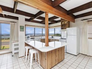 eine Küche mit weißen Geräten und einem großen Fenster in der Unterkunft Swimmers Rest in Port Fairy