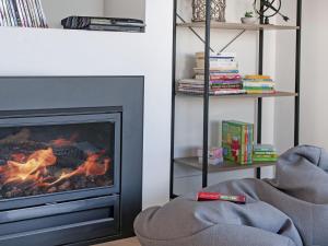 a living room with a fireplace and a chair at Bliss @ South Beach in Port Fairy