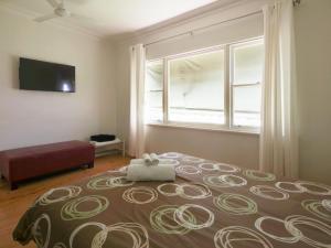 Un dormitorio con una cama grande y una ventana en Mary Grant, en Port Fairy