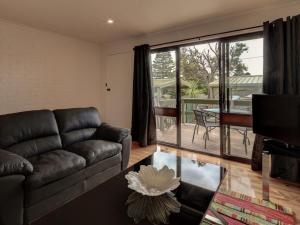 a living room with a couch and a table and a balcony at Malseeds in Port Fairy