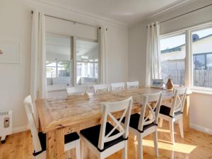 una sala da pranzo con tavolo e sedie in legno di Mary Grant a Port Fairy