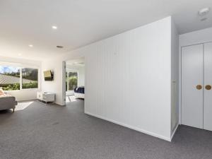 una sala de estar con una gran pared blanca en East Beach Retreat, en Port Fairy