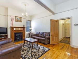 a living room with leather furniture and a fireplace at Fairholme Townhouse in Warrnambool