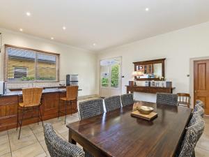 a kitchen and dining room with a wooden table and chairs at Fairholme Townhouse in Warrnambool
