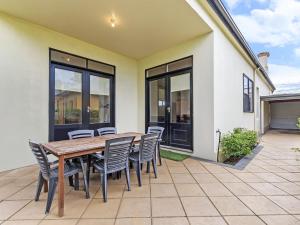 a wooden table and chairs on a patio at Fairholme Townhouse in Warrnambool