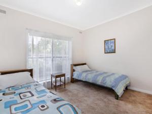 a bedroom with two beds and a window at Kurrawa in Port Fairy