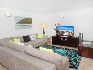 a living room with two couches and a flat screen tv at Headlands 10 Two Bedroom Beachside Apartment with Magical Ocean Views Great Value for Money in Alexandra Headland
