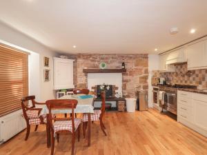 a kitchen with a table and chairs and a brick wall at Seaview in Nairn